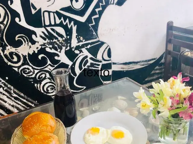 Breakfast with eggs, bread, juice and coffee at My Friend Surf Hostal