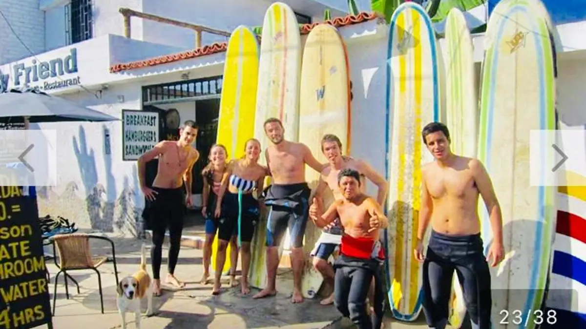 Surfers with their boards at the entrance to My Friend Surf Hostal